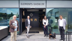 vier Personen eine mit Hund die in die Kamera lachen